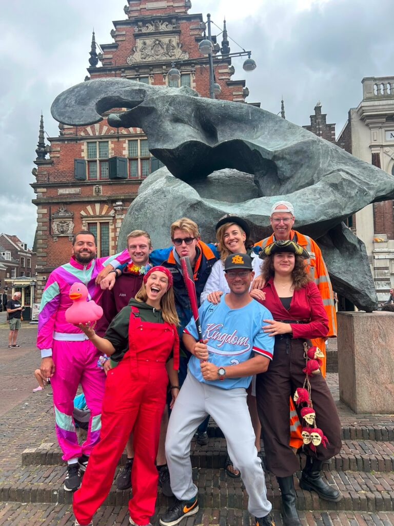 Groep verklede leden van Scouting Terraqua bij een standbeeld