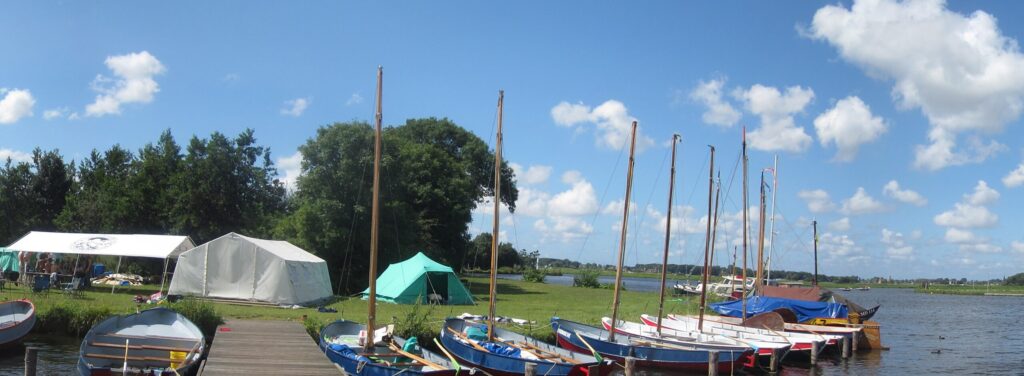 Jachthaven met zeilboten en tenten aan de Kaag