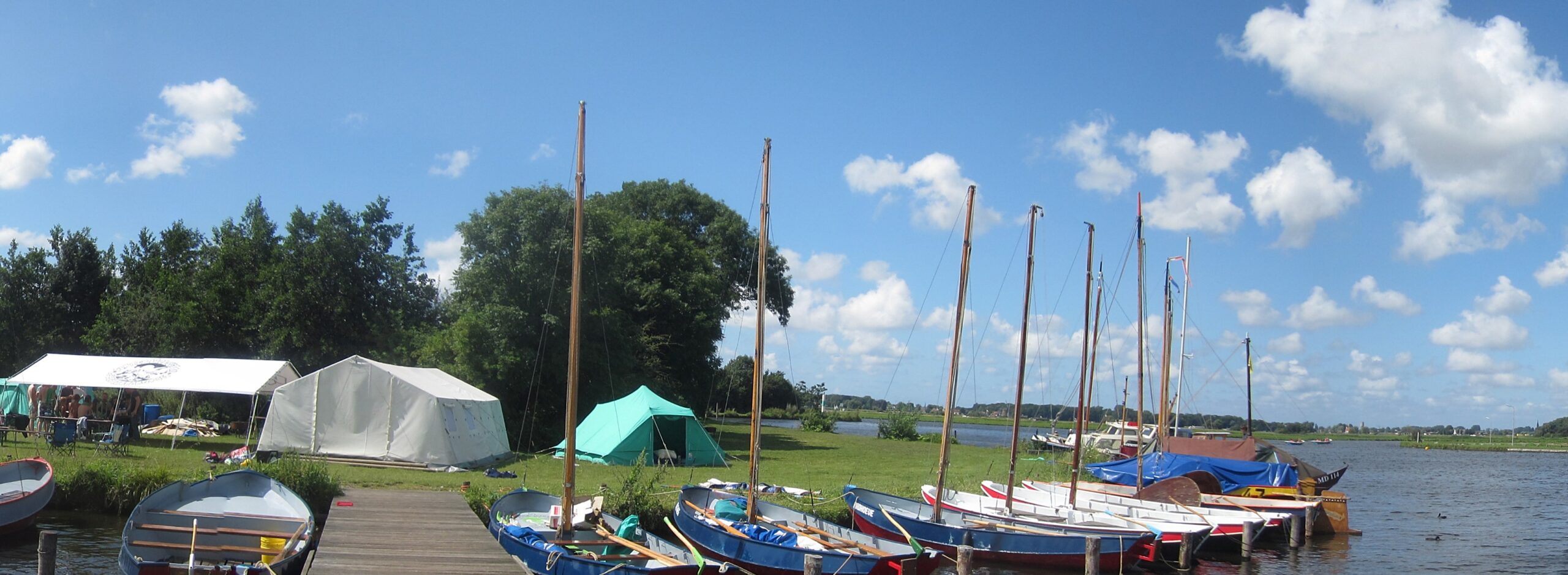 Jachthaven met zeilboten en tenten aan de Kaag