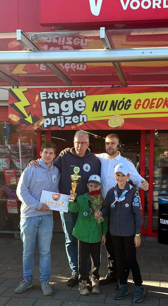 Leden van Scouting Terraqua met de beker, rozen en cheque bij de Vomar